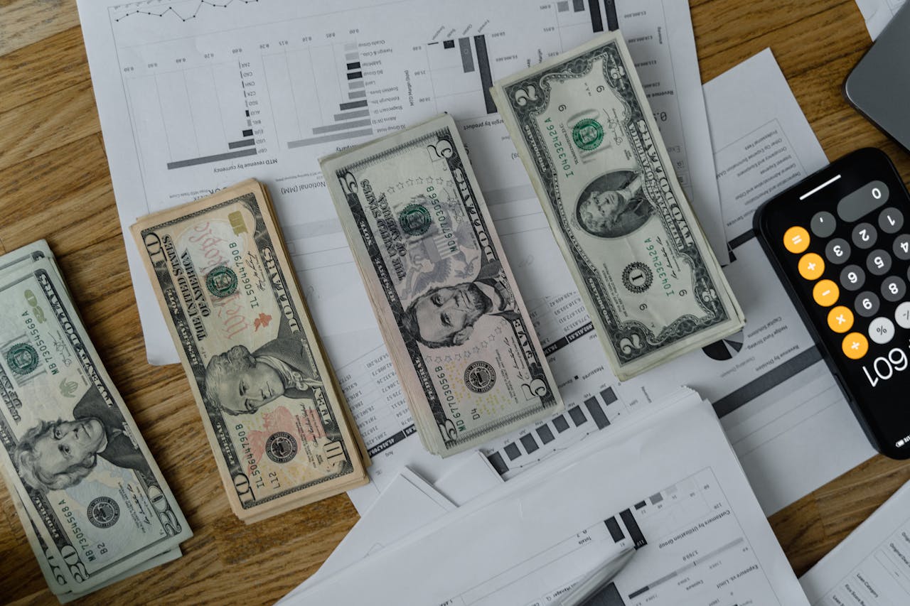 Services A workspace setup featuring cash, documents, and a calculator symbolizing financial analysis and budgeting.